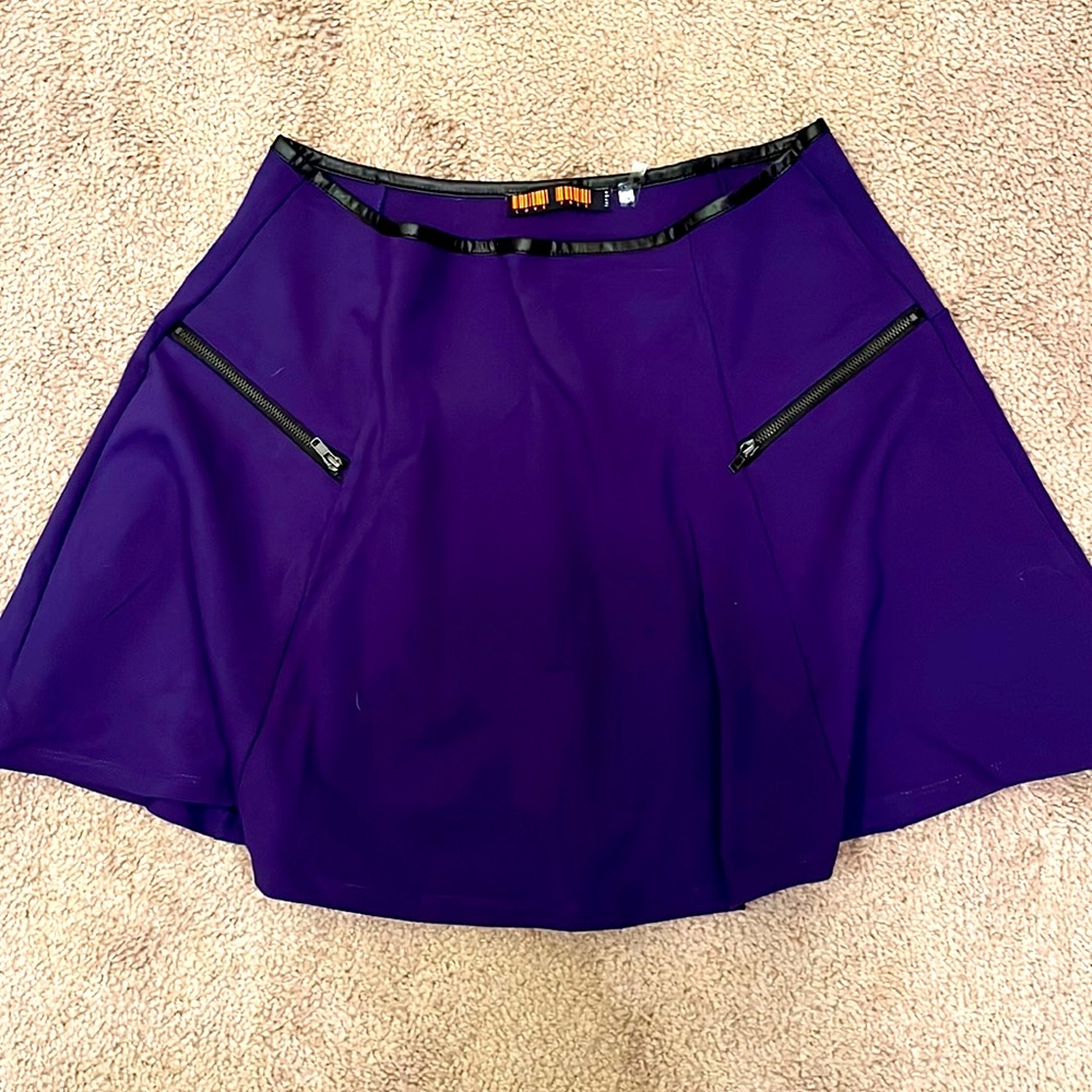 Royal blue stretchy skirt with pleats, zippers, and leather lining the top hem.